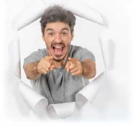 Hombre sonriente que señala al frente asomado a través de un papel rasgado